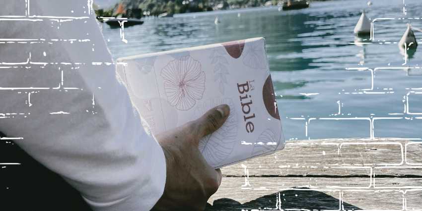 un hombre aguantando la biblia en un puerto