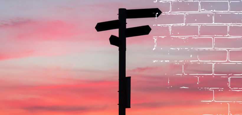 un poste de direcciones en un fundo de atardecer
