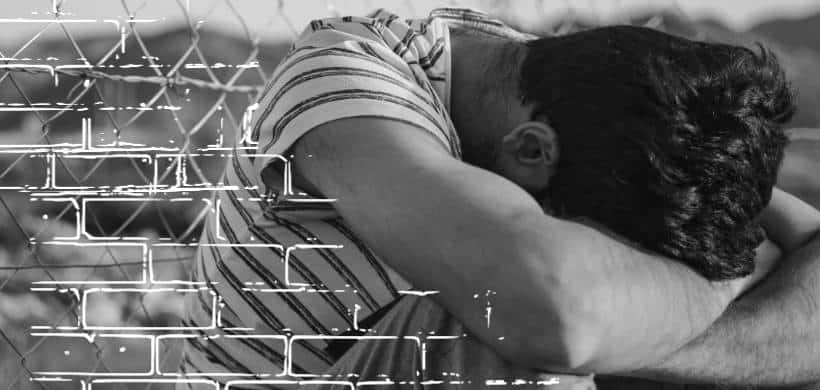 un hombre sentado con su cabeza abajo