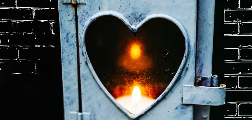 un horno de fuego que tiene una venta de forma de un corazón, adentro se ve un fuego ardiendo